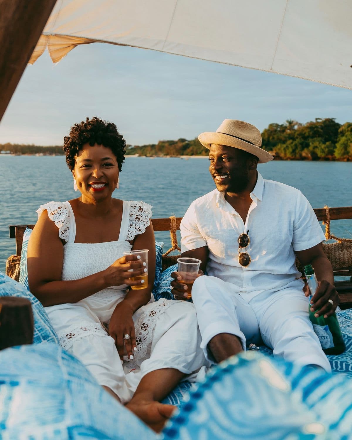 Couple relaxing with drinks on a boat cruise at golden hour